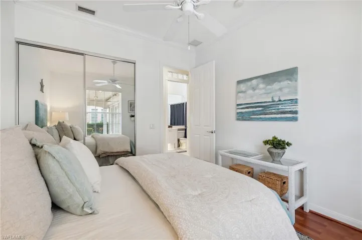 Bedroom with crown molding, ceiling fan, a closet, and wood-type flooring