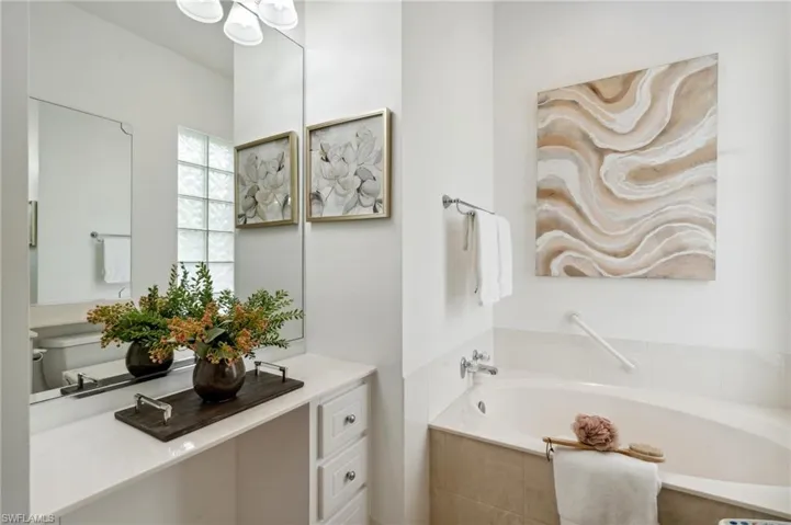 Her Master Bathroom with vanity and tiled tub