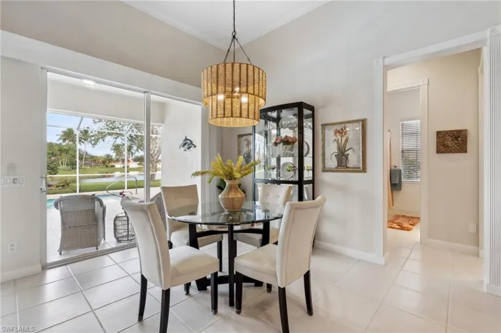 Dining room featuring light tile patterned floors, crown molding, and an inviting chandelier