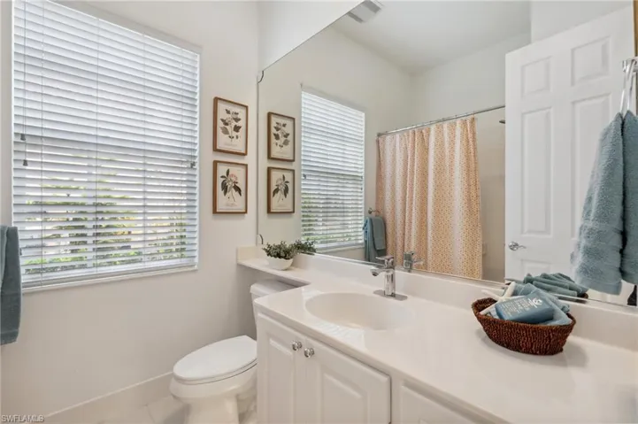 Bathroom with tile patterned flooring, vanity, a healthy amount of sunlight, and toilet