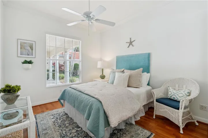 Bedroom with ceiling fan, wood-type flooring, and crown molding