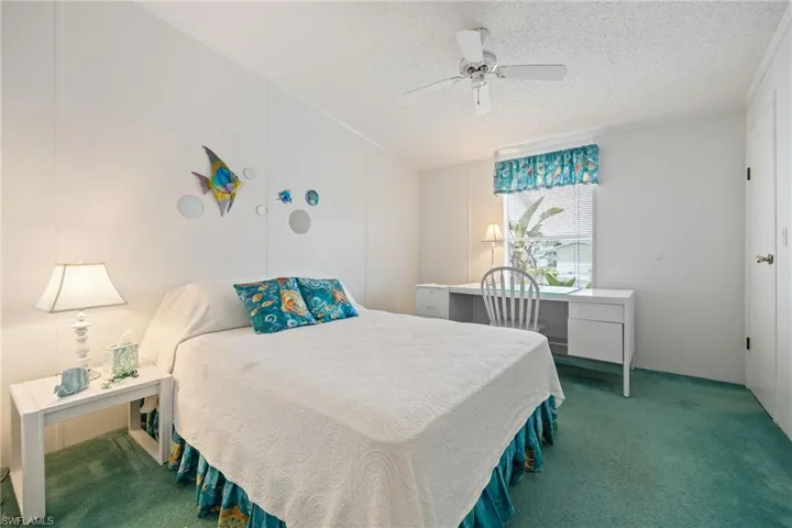Light and bright guest bedroom featuring a ceiling fan, and an office space