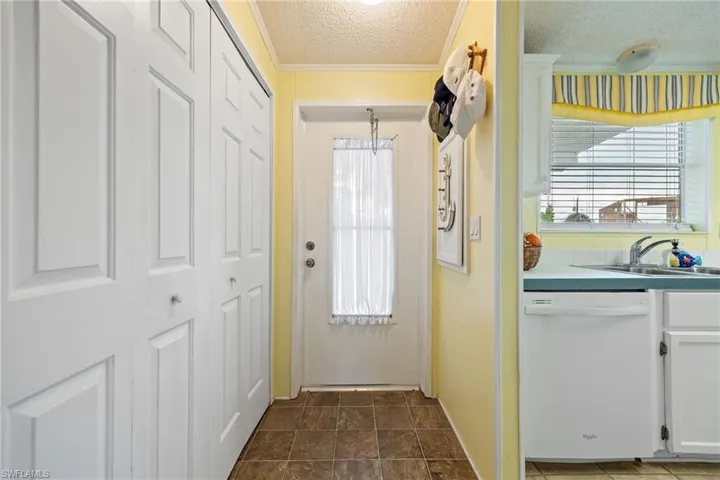 Entryway featuring a textured ceiling and ornamental molding