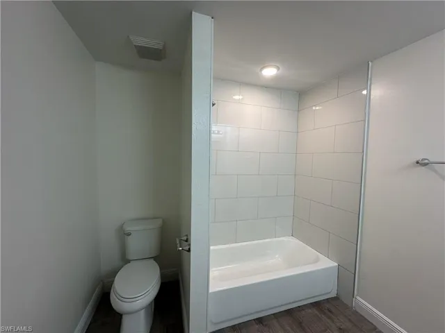 Full bath featuring  shower combination and wood finished floors