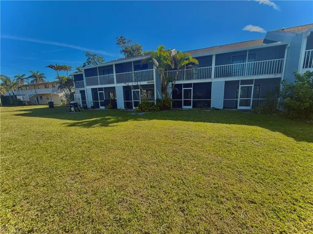 Back of property with a sunroom and a yard