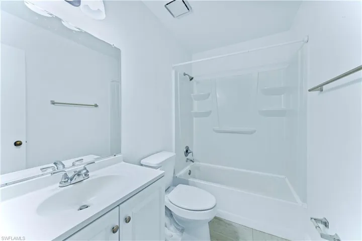 Full bathroom featuring toilet, tub / shower combination, vanity, and tile patterned flooring