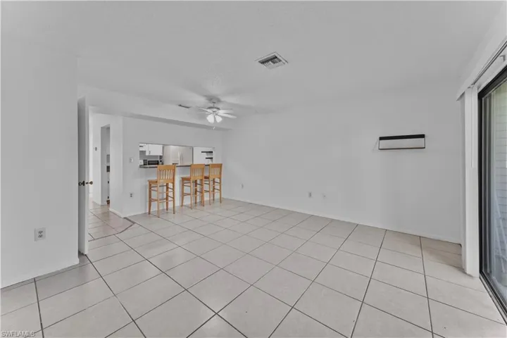 Unfurnished living room featuring a textured ceiling, ceiling fan, and light tile patterned floors