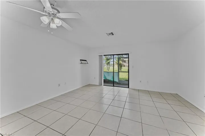 Unfurnished room with light tile patterned flooring, ceiling fan, and a textured ceiling