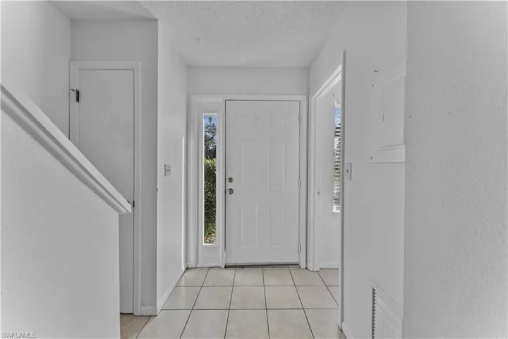 Entrance foyer featuring a textured ceiling and light tile patterned flooring