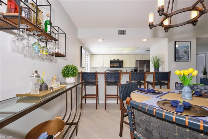 Dining space offers plenty room for entertaining with breakfast bar, living/dinging combo, light wood-style LTV floors, recessed lighting, a chandelier.