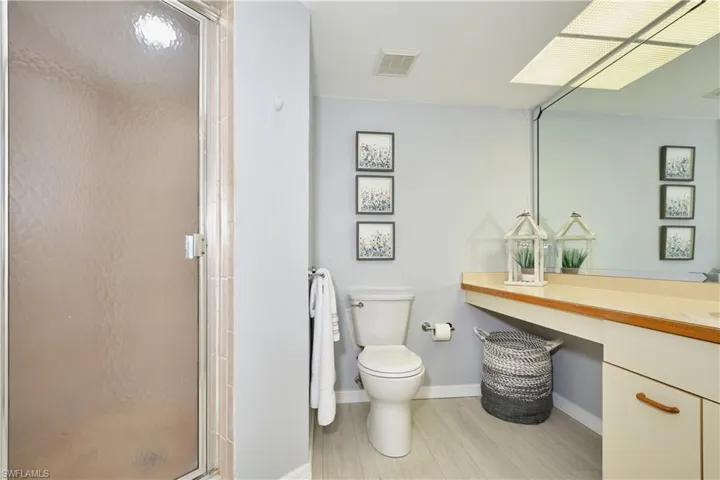 Owners bath with shower, vanity, and cabinet storage.