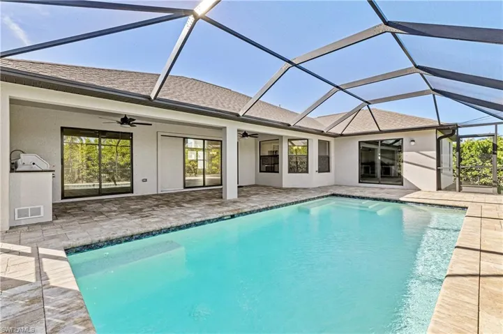 Outdoor pool with a patio area, a sunroom, and a lanai