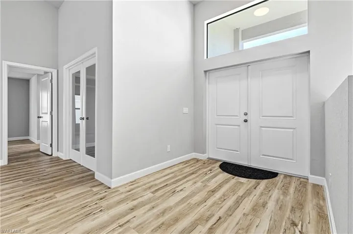 Entryway with a towering ceiling and light wood-style floors
