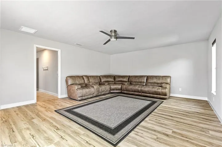 Living room featuring ceiling fan and light wood-style flooring
