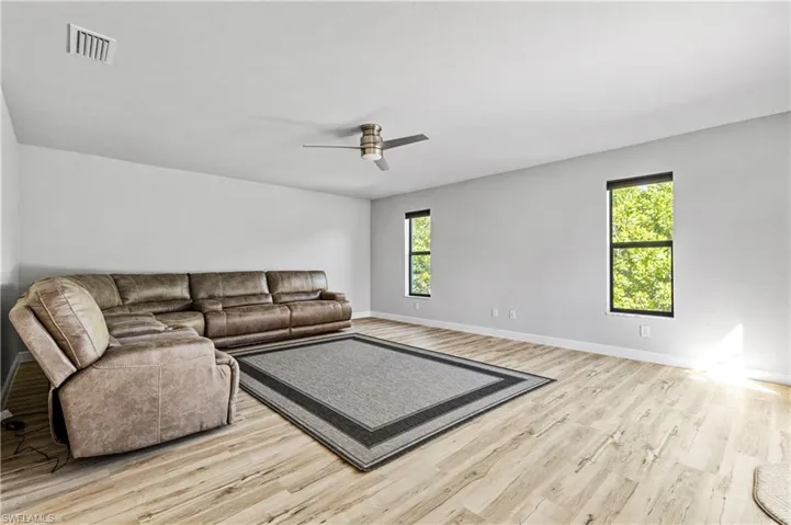Living room with light wood finished floors and ceiling fan
