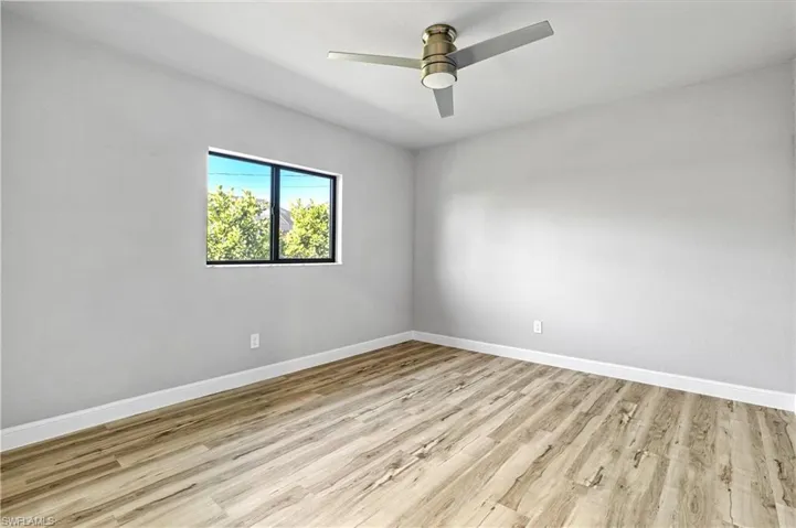 Empty room featuring light wood-style flooring and a ceiling fan