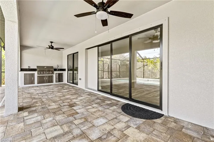 View of patio with a ceiling fan and an outdoor kitchen