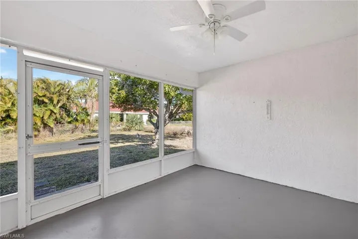 Unfurnished sunroom featuring ceiling fan