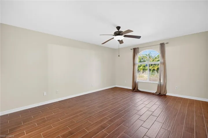 Unfurnished room with wood tiled floors and a ceiling fan