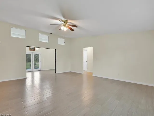 Empty room with french doors, a ceiling fan, and light wood-style floors