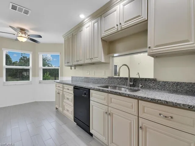 Kitchen with dishwasher, dark stone countertops, a ceiling fan, and recessed lighting