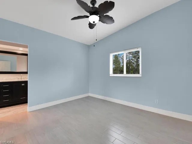 Spare room with light wood-style flooring, lofted ceiling, and a ceiling fan
