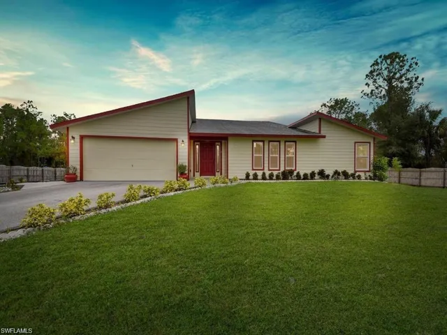 View of front of property with an attached garage and asphalt driveway