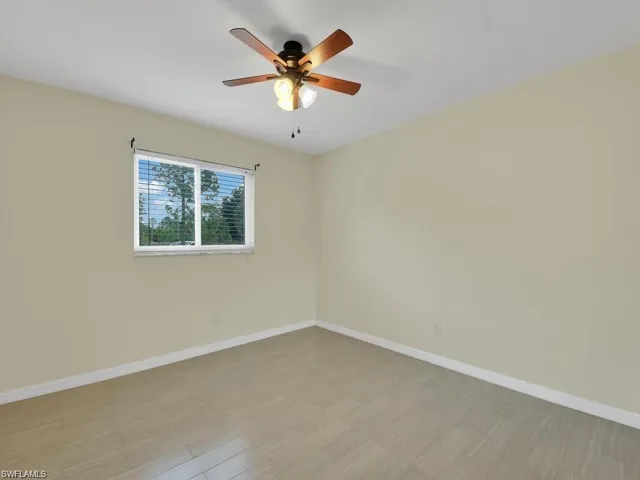 Unfurnished room featuring wood finished floors and a ceiling fan
