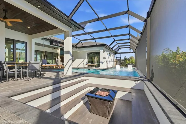 Outdoor pool featuring a patio, a sunroom, outdoor dining area, and a lanai