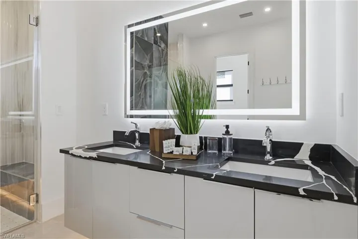 Bathroom with double vanity, a marble finish shower, recessed lighting, and light tile patterned floors
