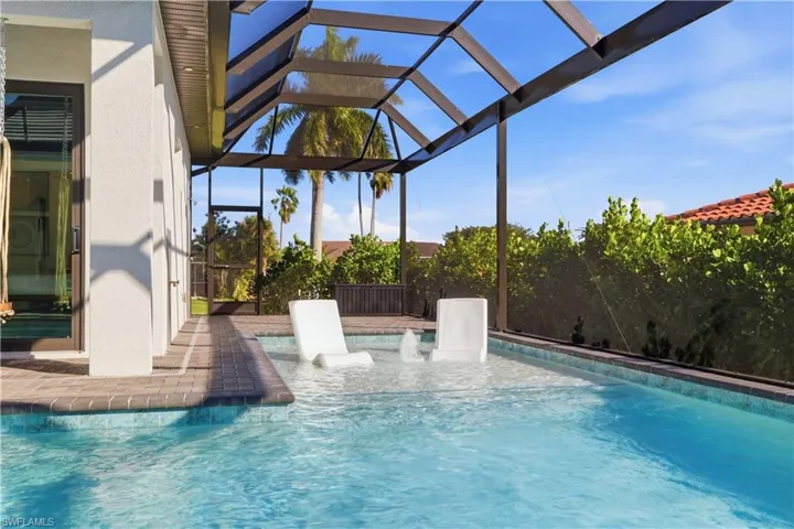 Outdoor pool with glass enclosure, a patio, a sunroom, and a pergola