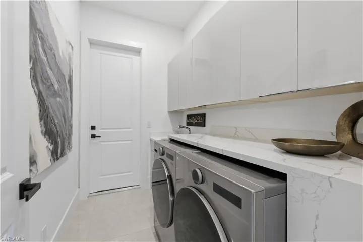 Laundry room featuring cabinet space and washer and clothes dryer