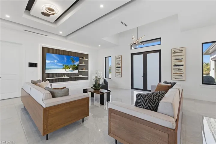 Living area with french doors, a high ceiling, and recessed lighting