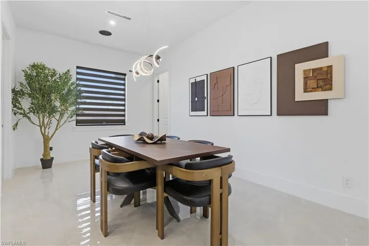 Dining area featuring baseboards and a chandelier