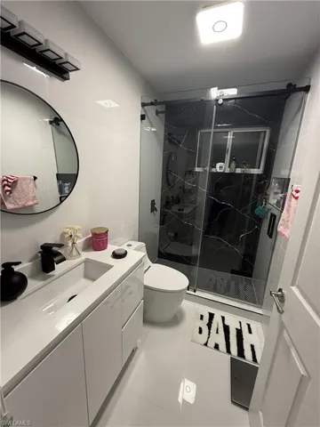 Bathroom with vanity and a marble finish shower