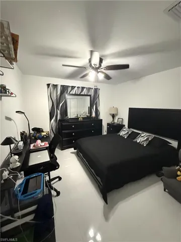 Bedroom with ceiling fan and an office area