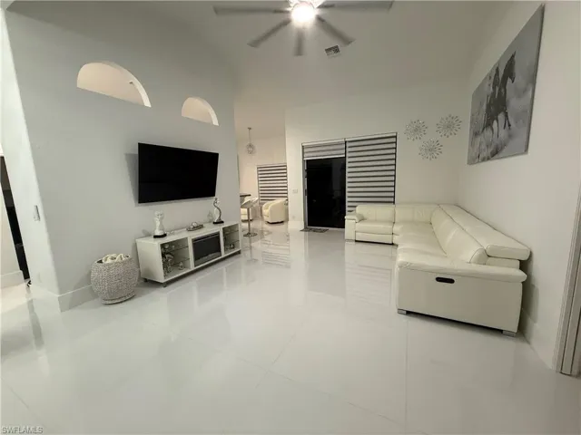 Living area with light tile patterned flooring and a ceiling fan