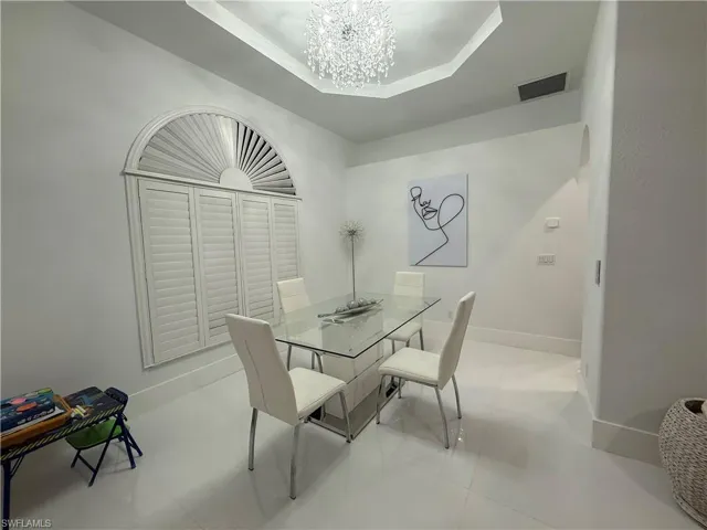 Dining room featuring a tray ceiling and a chandelier
