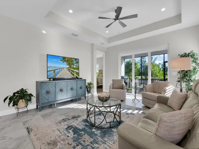 Living area featuring a tray ceiling, a ceiling fan, and recessed lighting