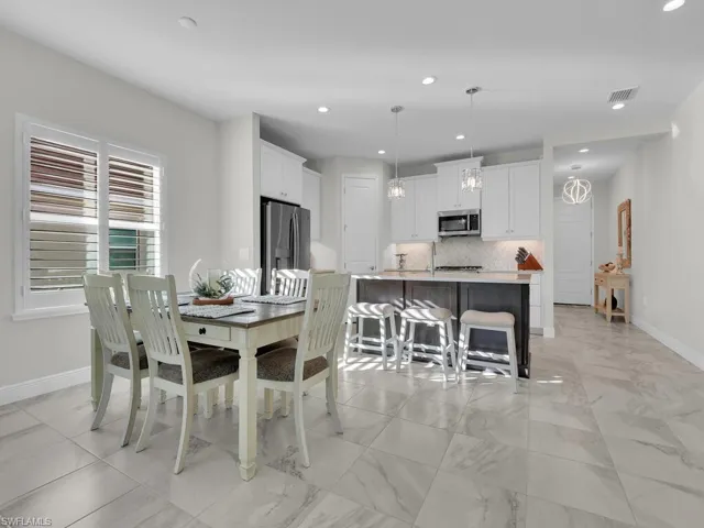 Dining room featuring recessed lighting and light marble finish floors