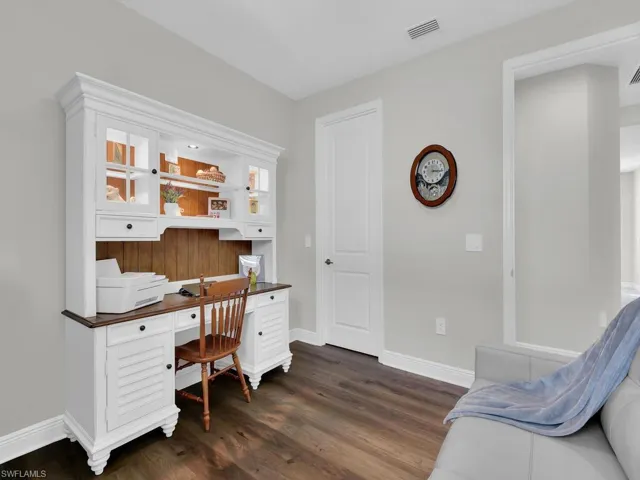 Home office with dark wood finished floors and baseboards