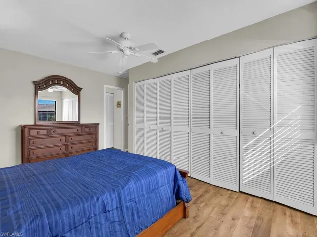 Bedroom with light wood-style flooring, ceiling fan, and a closet