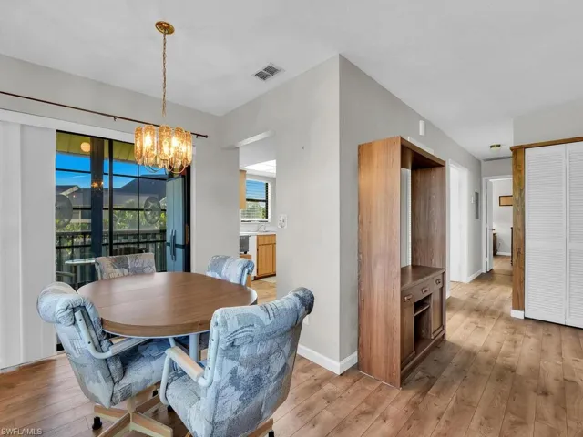 Dining space with light wood-type flooring and a chandelier