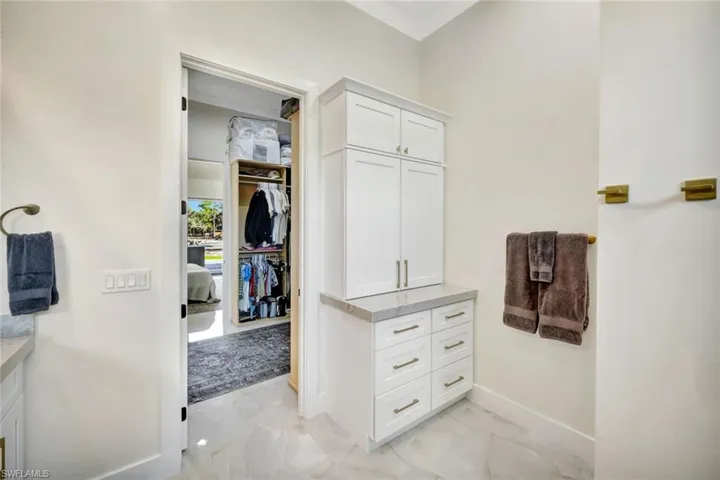 Walk in closet with light marble finish floors