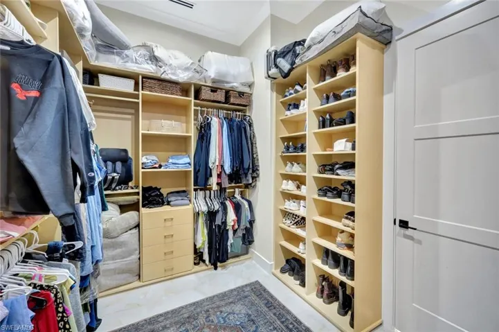 Walk in closet featuring light marble finish floors
