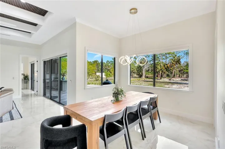 Dining space featuring light marble finish flooring, cooling unit, and a chandelier