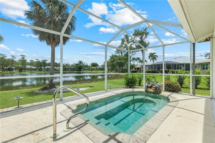 Swimming pool with a water view, a lawn, a lanai, and a patio area