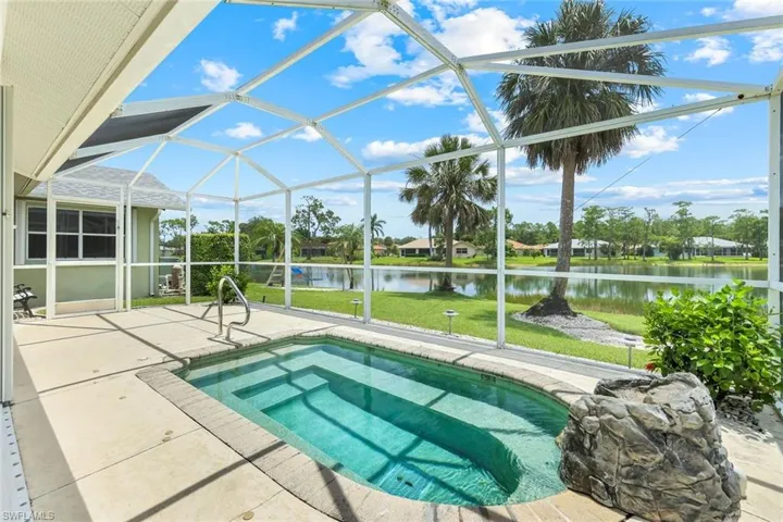 View of swimming pool with a patio area, a pool, a water view, and glass enclosure