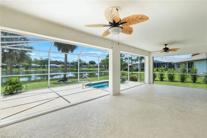 Swimming pool featuring a patio, a water view, ceiling fan, and glass enclosure