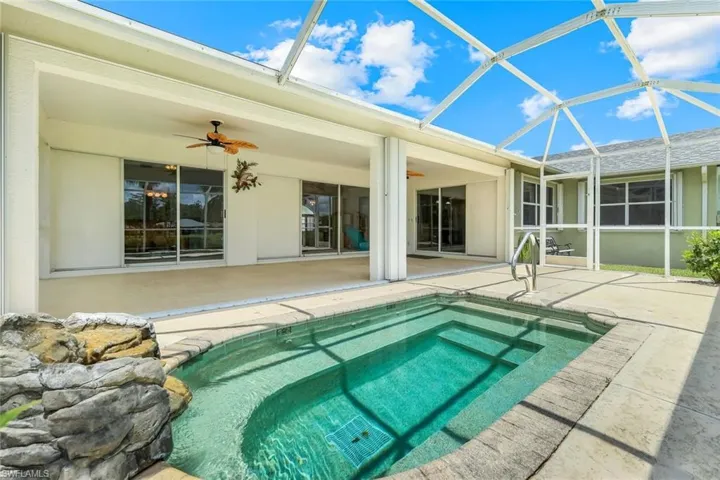 Outdoor pool featuring ceiling fan, a patio, and glass enclosure